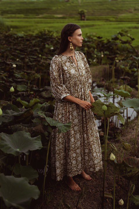 Daughters of India Kyra Maxi Dress in Olive — side profile in lotus pond with rice paddies, gathered waist detail