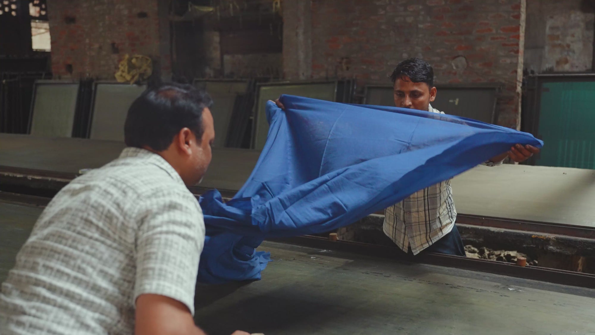 Making of Zahra Indigo - discharge screen printing in landscape, artisans printing onto indigo-dyed fabric using screen stencils